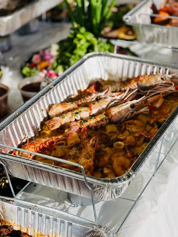 Mastering the First Impression: Your intriguing post title goes here Tempting close-up of grilled seafood in a catering tray, perfect for buffet meals.